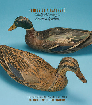 Cover of the 'Birds of a Feather' exhibition catalog featuring two carved wooden decoys of waterfowl on a blue background.